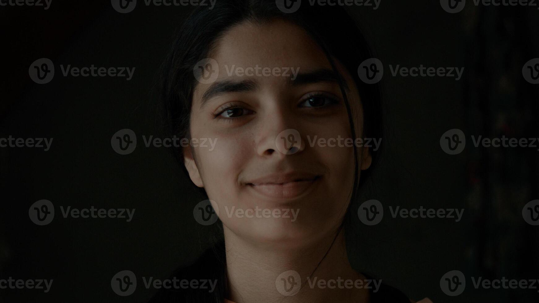 menina olha sorrindo para a lente da câmera foto