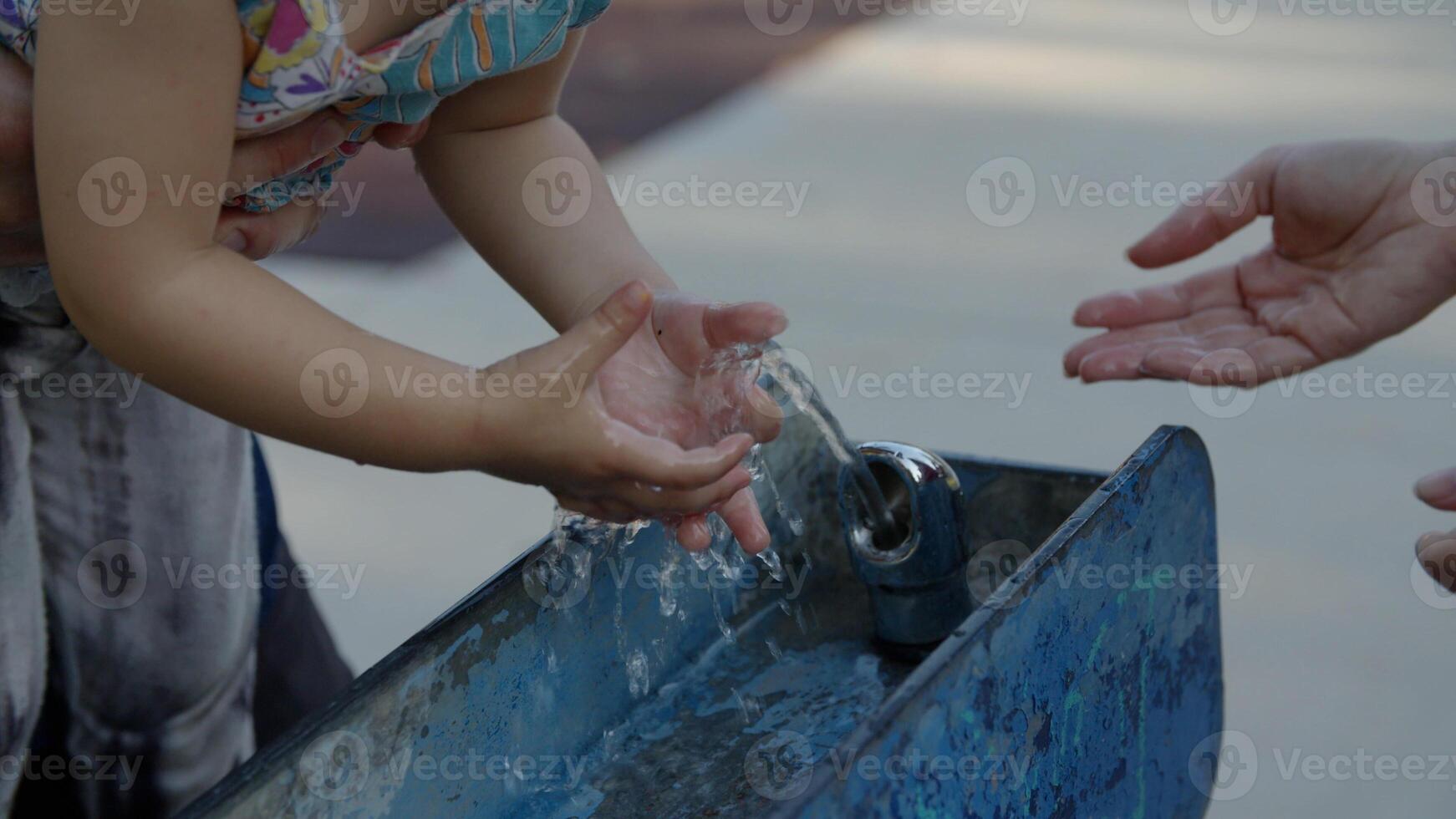 câmera lenta de menina tocando água na fonte foto