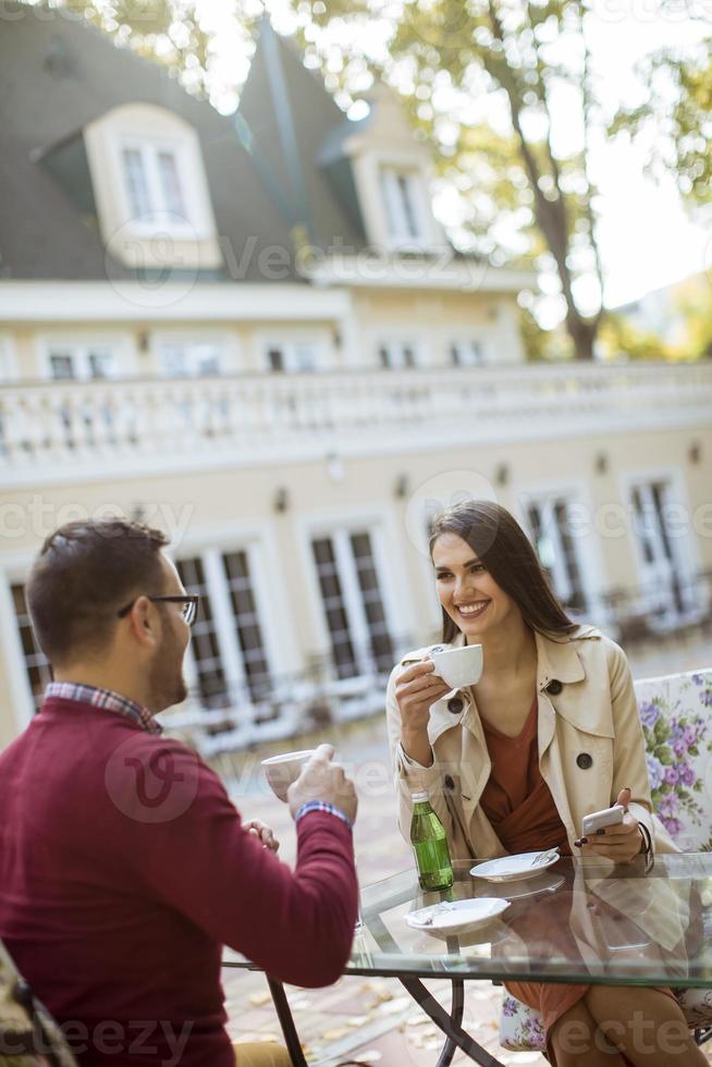 jovem casal se divertindo enquanto estão sentados juntos em um café da cidade foto