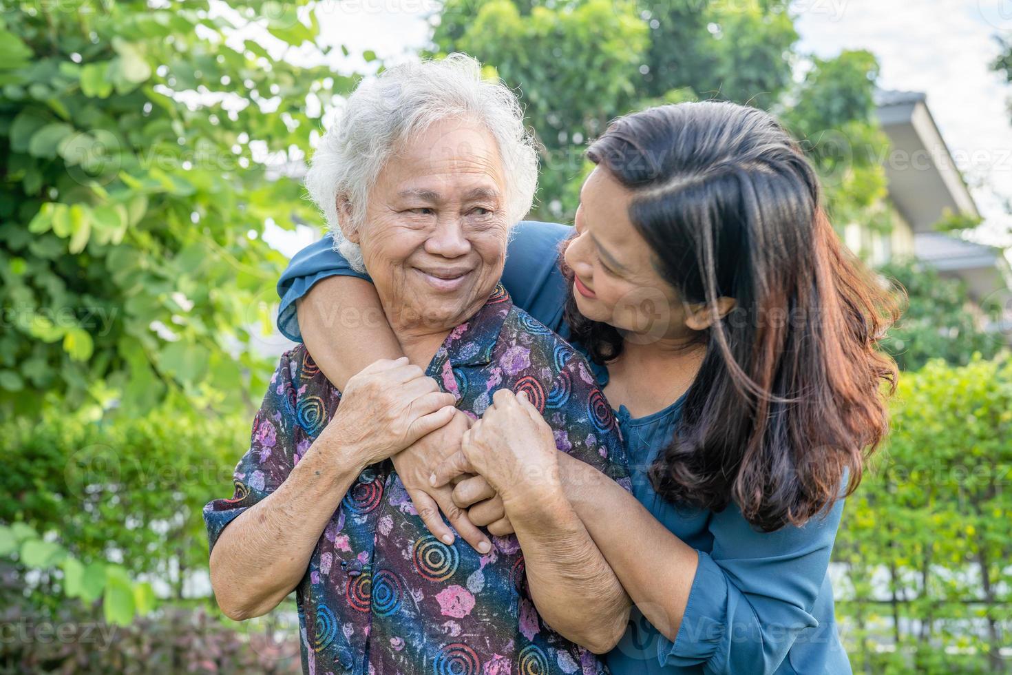 mulher idosa asiática com cuidador andando com feliz no parque natural. foto