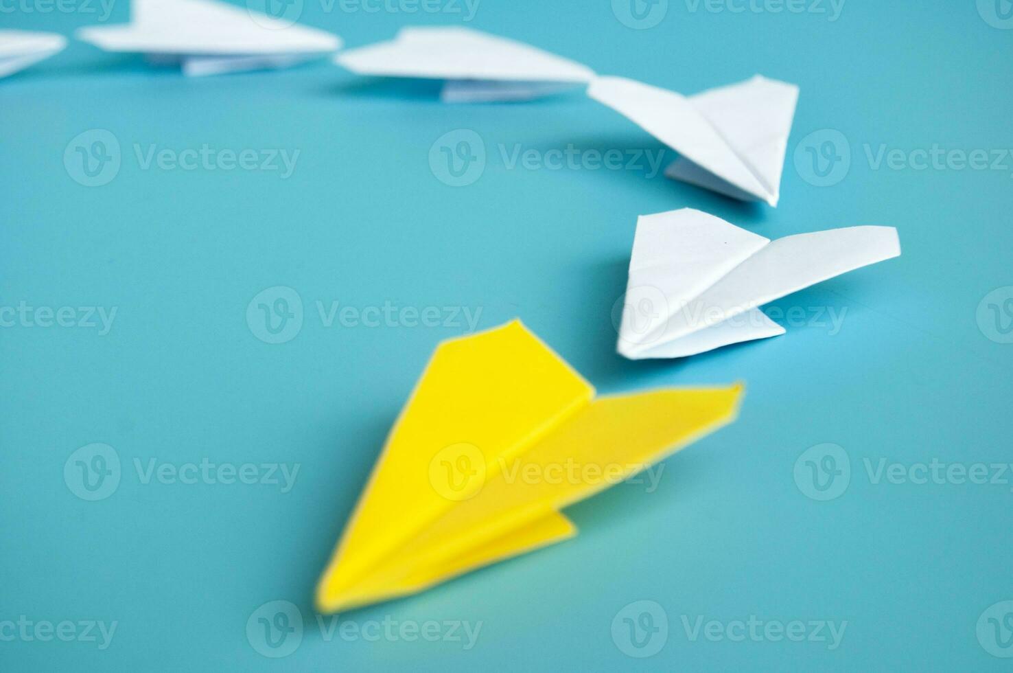 baixo Visão do amarelo papel avião origami conduzindo branco papel aviões. com cópia de espaço para texto. foto