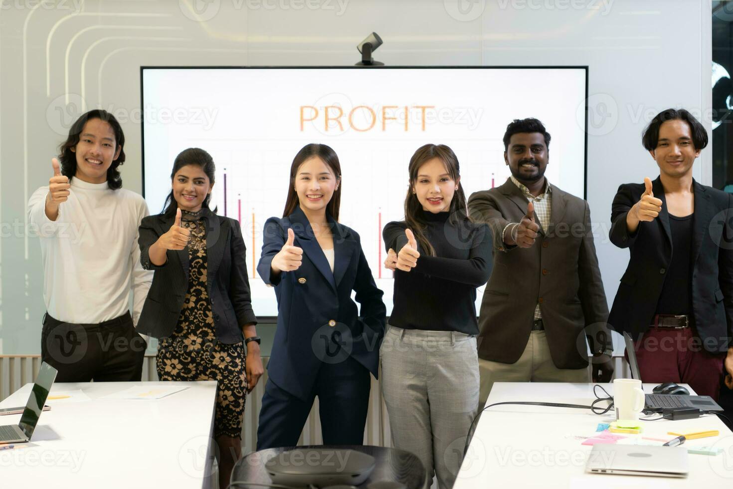 uma grupo do multirracial pessoas de negócio dá a polegares acima dentro frente do a encontro sala, indicando a conceito do o negócio sucesso. foto