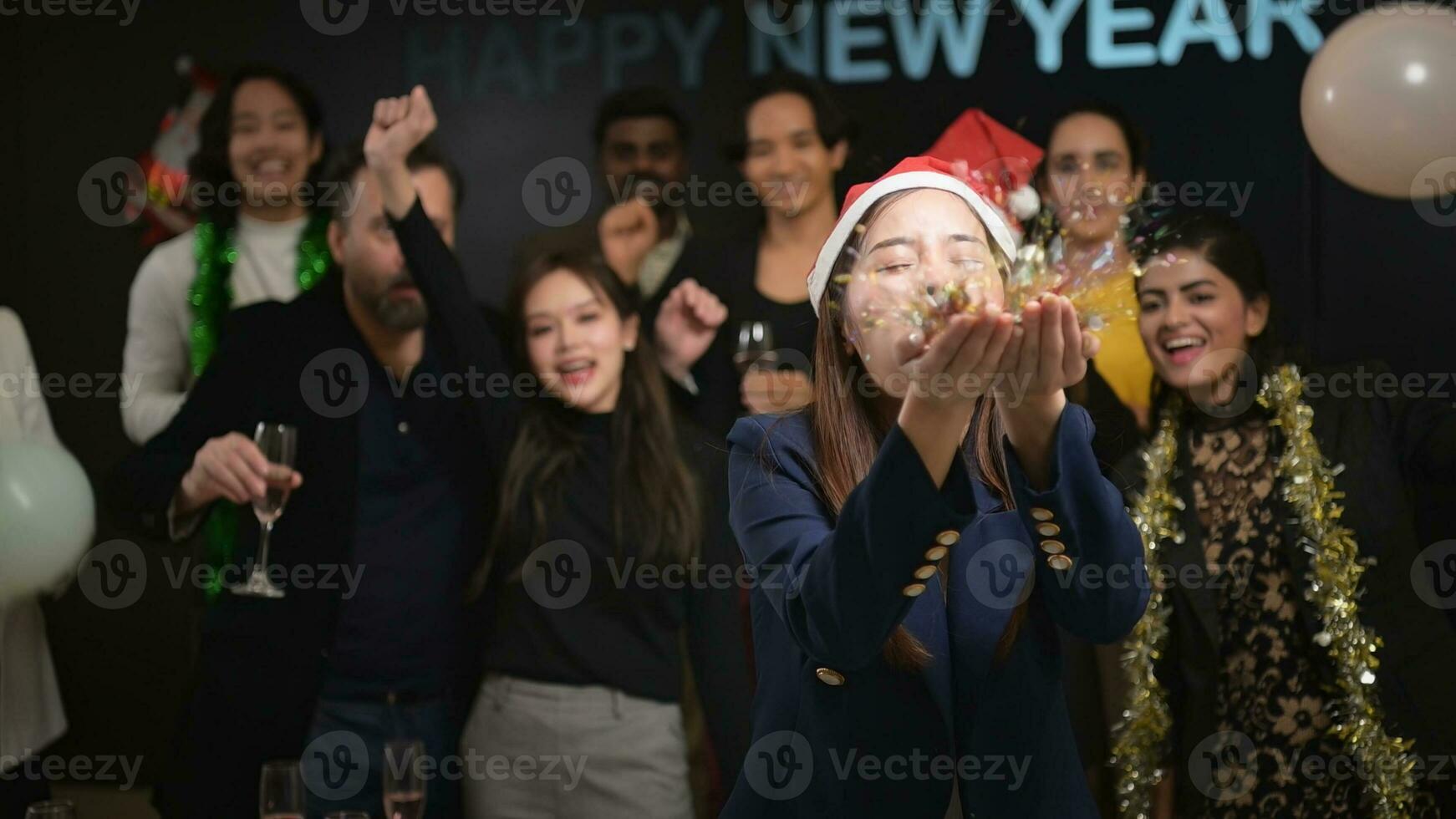Novo ano festa, grupo do jovem pessoas dentro santa chapéus sopro confete enquanto a comemorar Novo ano foto