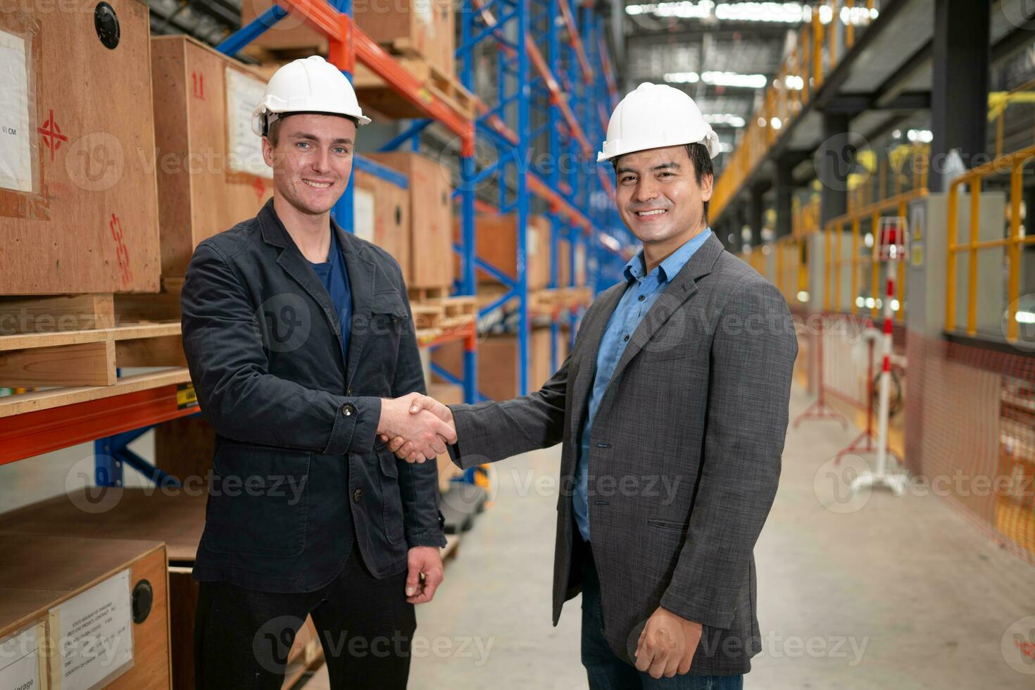 dois empresários tremendo mãos dentro uma armazém isto é uma armazém do poupar partes e equipamento para reparação maquinaria e passageiro carros dentro a skytrain transporte sistema. foto