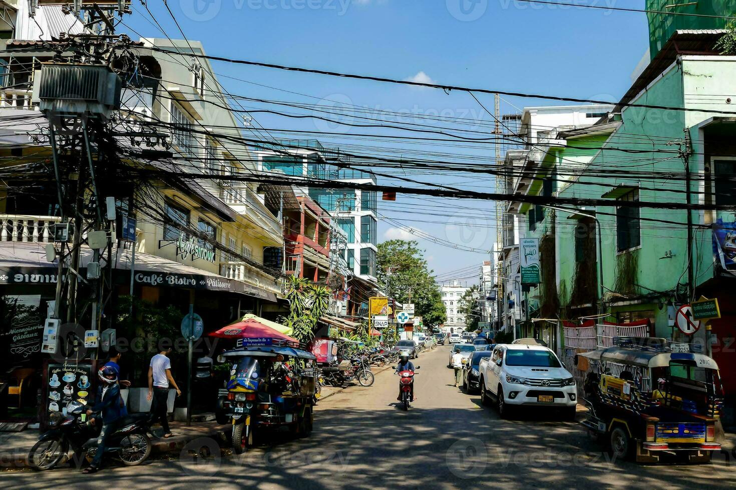 uma rua dentro a cidade com muitos edifícios e motocicletas foto