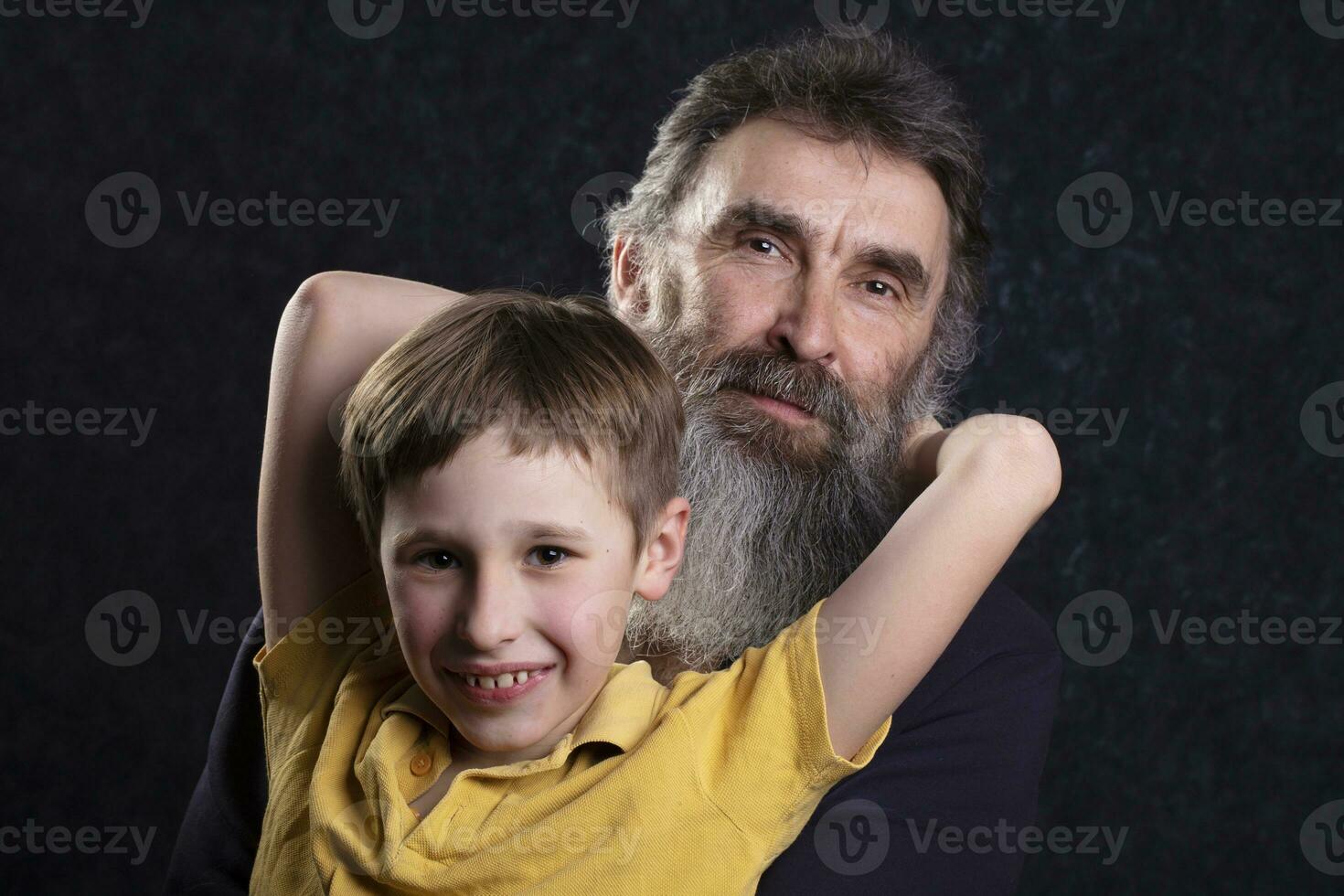 retrato do uma feliz avô com uma barba e Neto em uma Preto fundo. foto