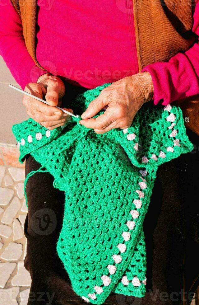 a Mais velho mulher é tricô uma cobertor foto