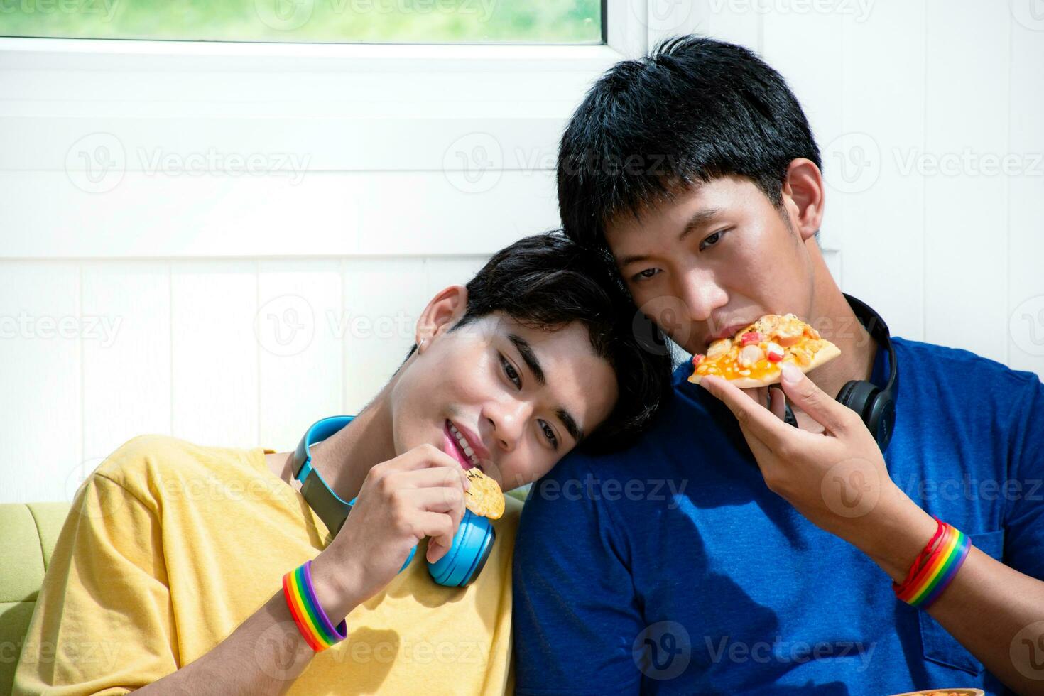 retrato do dois jovem ásia gay casais sentado em sofá, gastos seus livre Tempo e assistindo televisão às casa junto, conceito para estilo de vida do lgbt pessoas por aí a mundo. foto