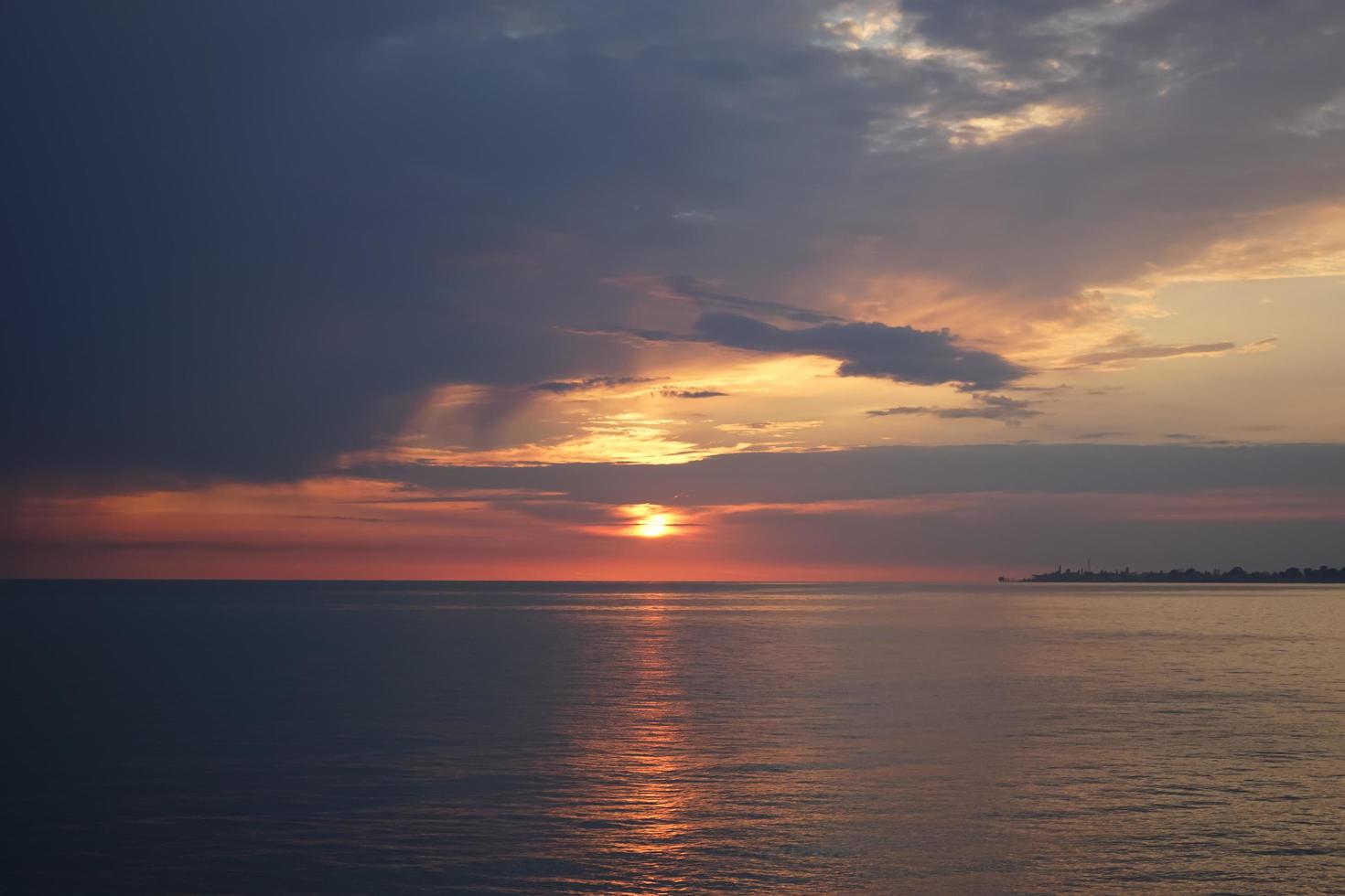 incrível pôr do sol no oceano. vista dramática do céu nublado foto