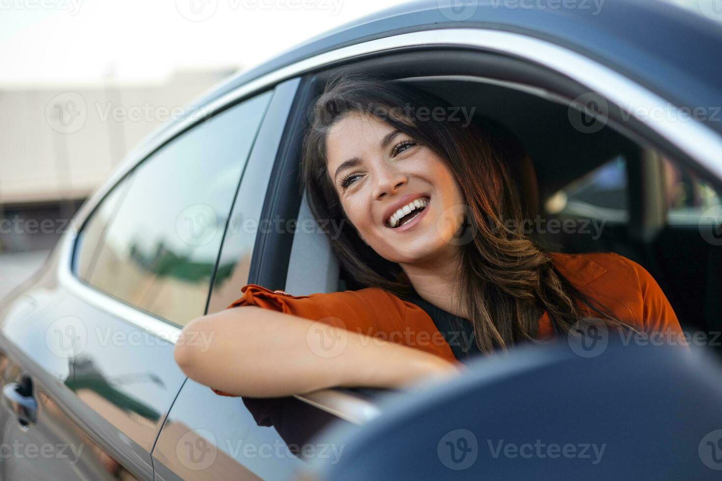 cortada tiro do a atraente jovem mulher inclinado Fora do uma carro janela em uma estrada viagem foto