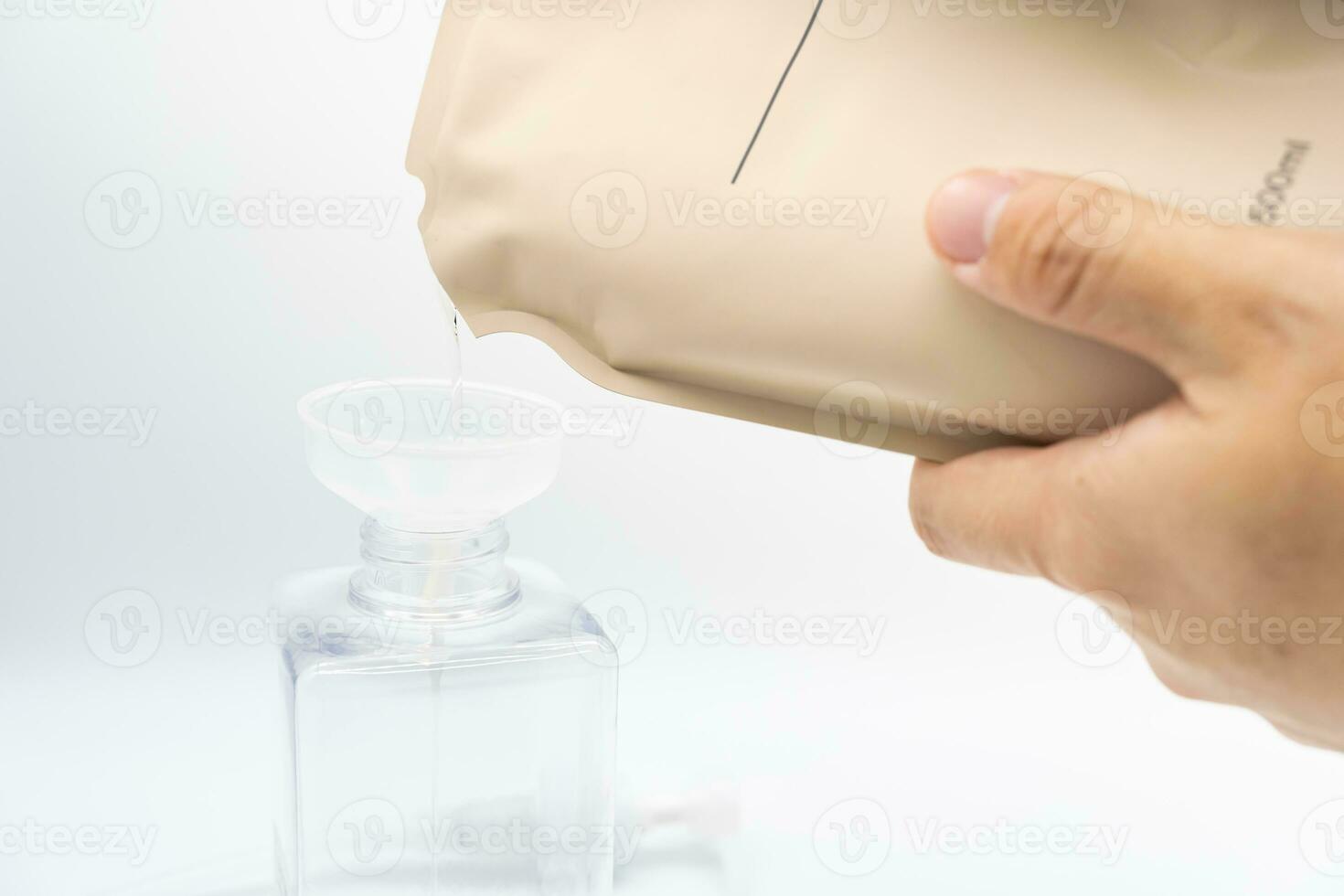 uma homem preenche uma distribuidor com líquido Sabonete de derramando isto a partir de uma reabastecer para reduzir plástico desperdício. Sabonete ou xampu para refil. foto