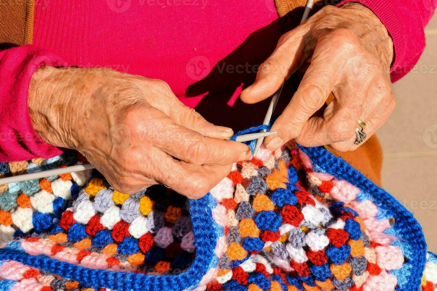 a Mais velho mulher é tricô uma colorida crochê cobertor foto