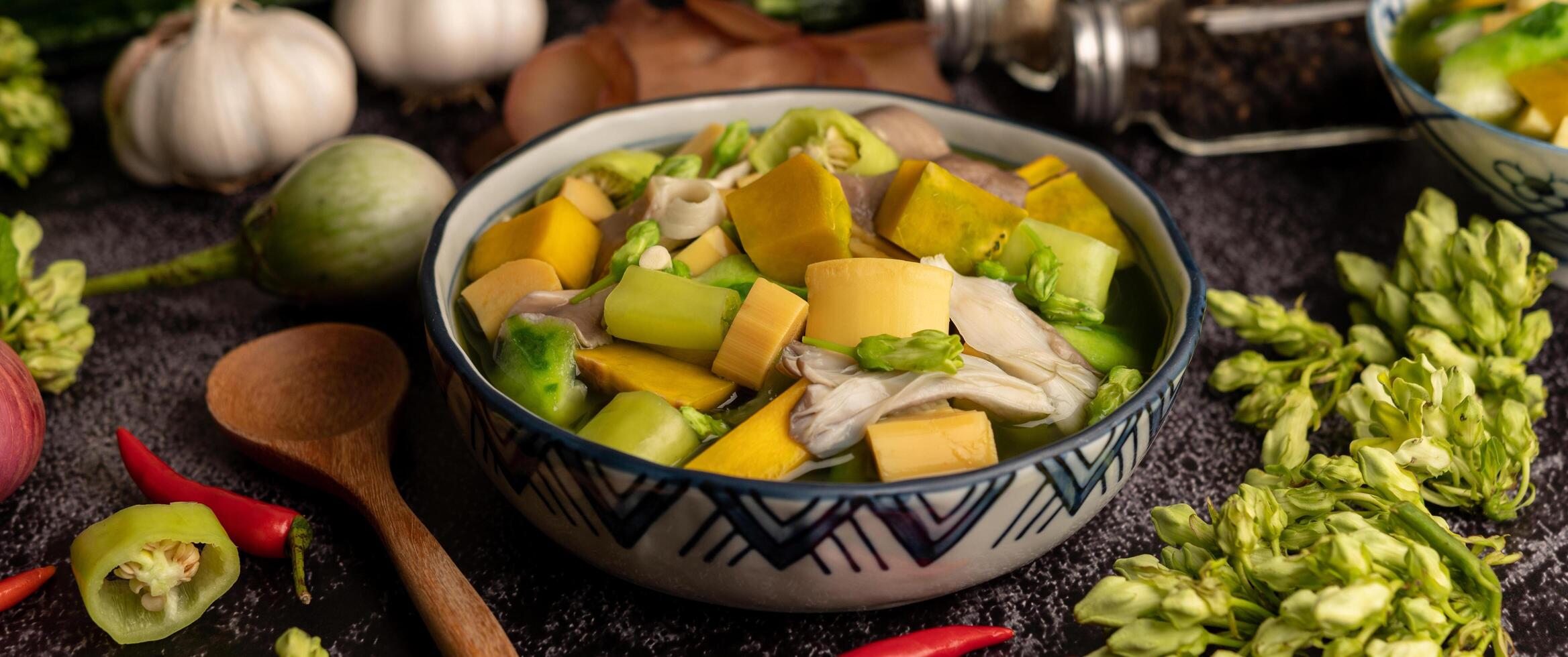 kaeng liang em uma tigela com especiarias no chão de cimento preto. foto