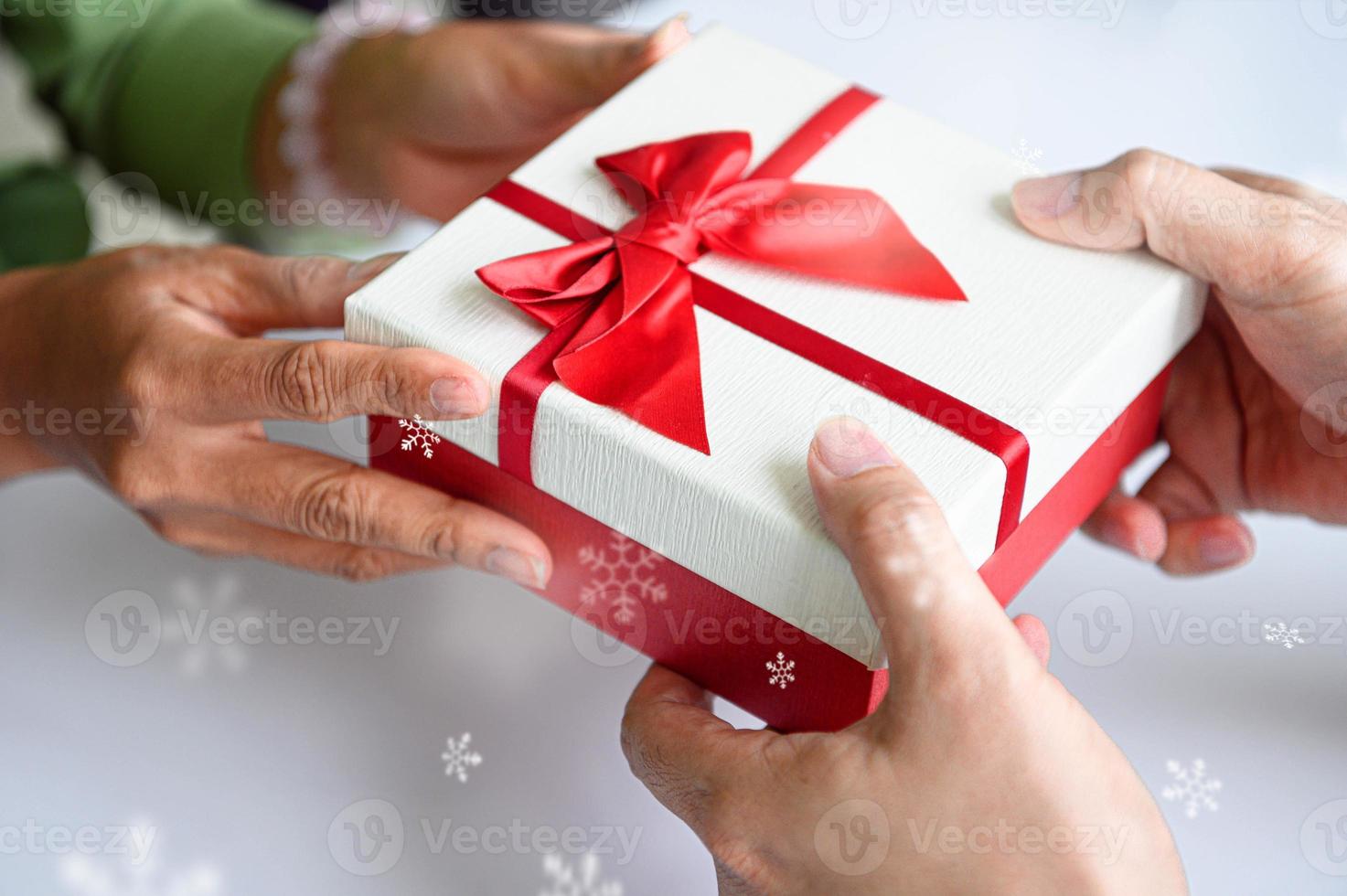 closeup de mãos dando uma caixa de presente no dia de natal e ano novo foto