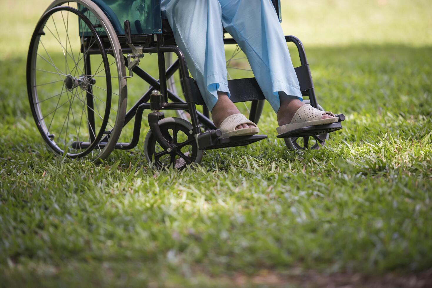 close-up idosa solitária sentada em uma cadeira de rodas no jardim foto