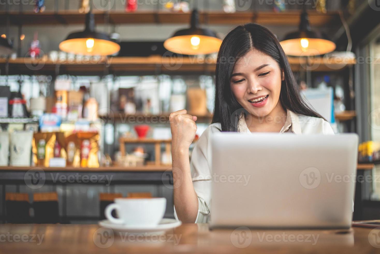 Freelancer feminina asiática fazendo um gesto feliz, levantando a mão foto