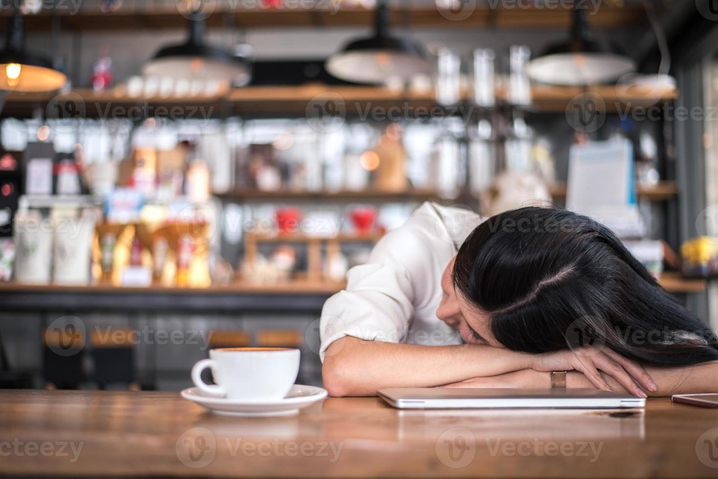 mulher asiática está descansando e dormindo em uma cafeteria foto