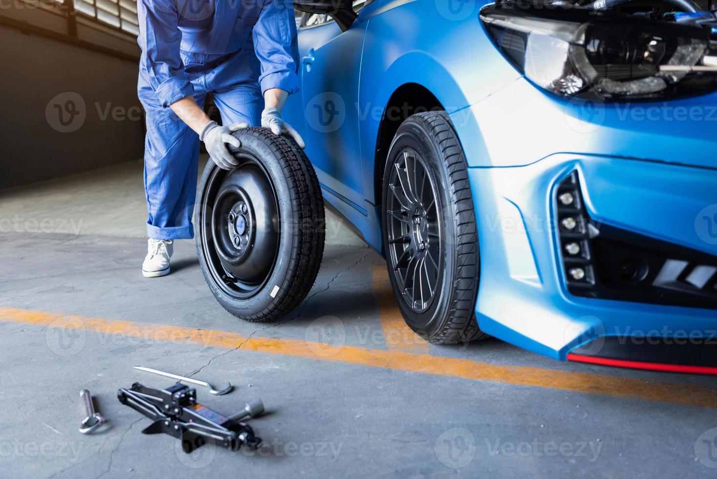 mecânico de automóveis trocando pneu em oficina mecânica foto