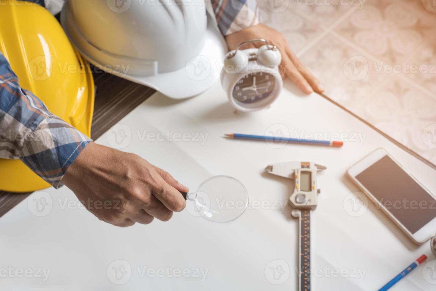 engenheiro com lupa para procurar papel em branco para novo projeto foto