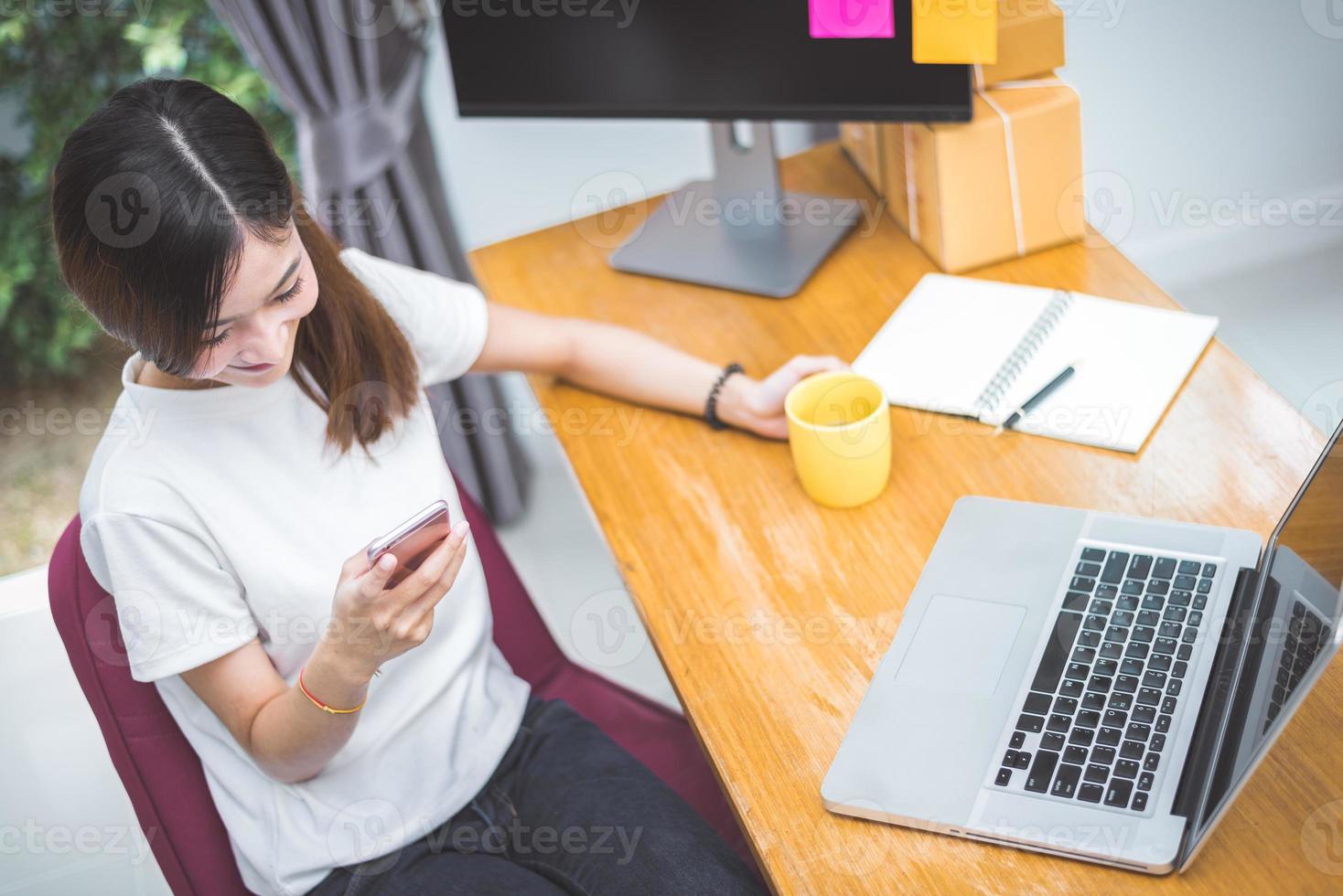 vista superior de uma mulher usando telefone celular e laptop para fazer compras foto