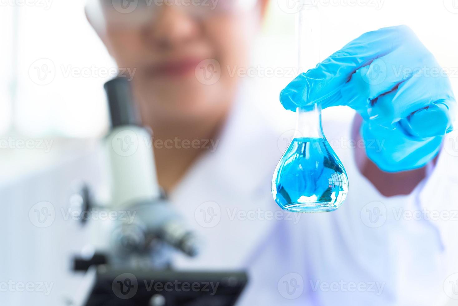 cientista segurando e mostrando tubos de ensaio de laboratório foto