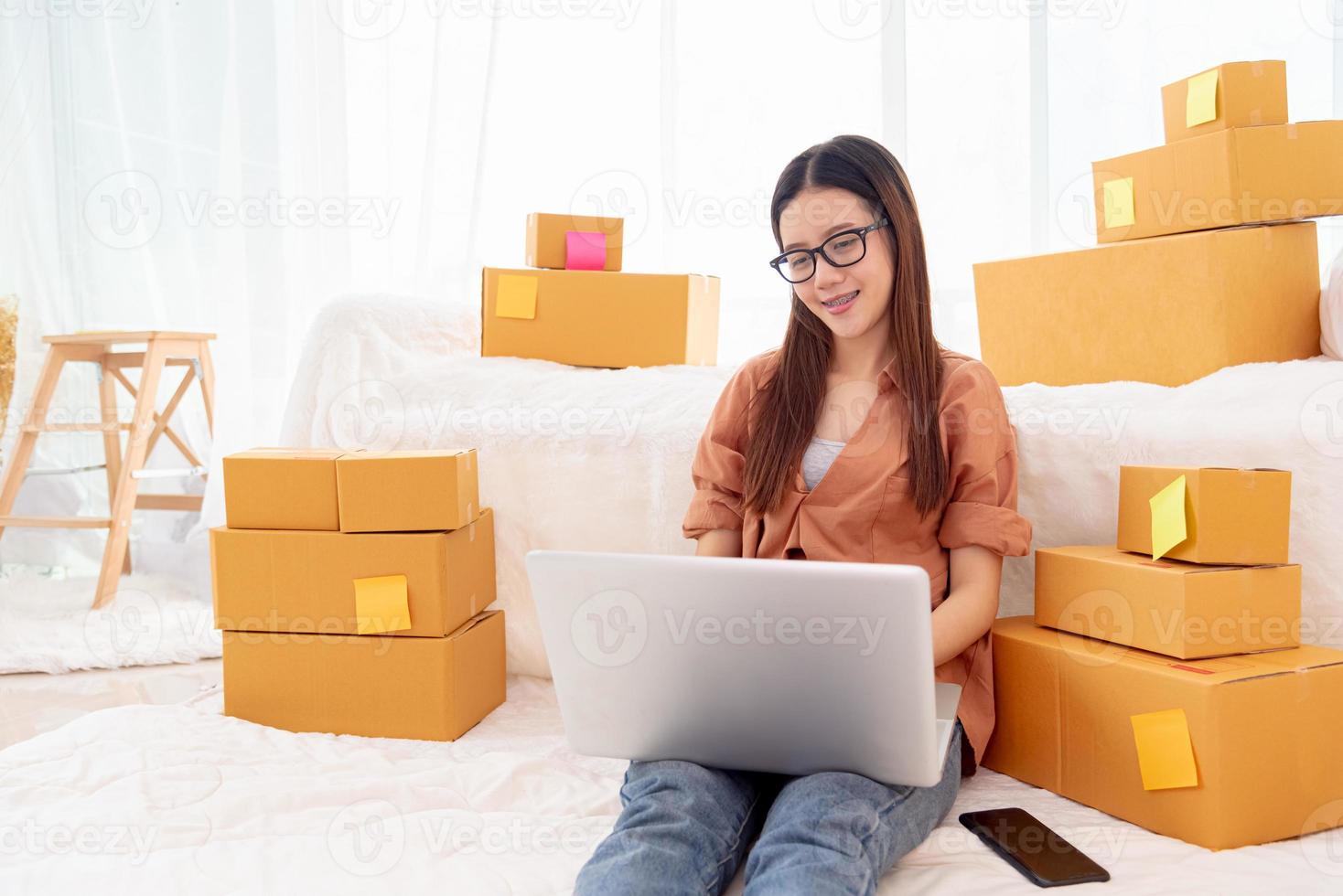 Mulher asiática bonita usando laptop para atendimento ao cliente no quarto foto