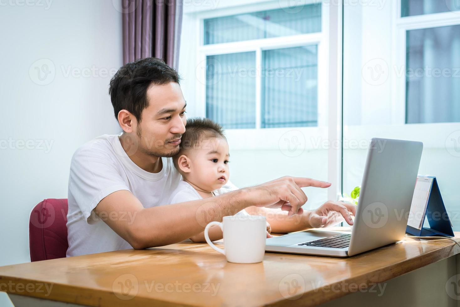 pai solteiro e filho usando laptop juntos e felizes foto