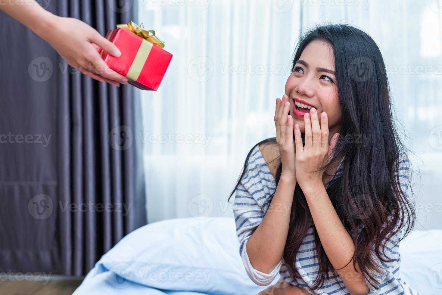 mulher asiática surpresa com o presente de aniversário foto