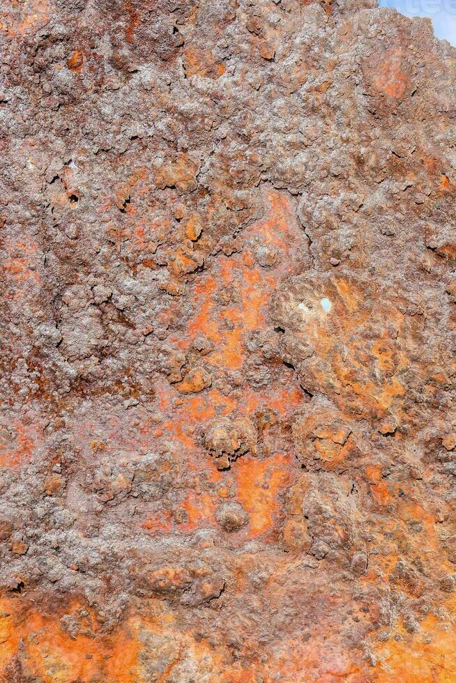 uma fechar acima do uma oxidado Rocha com laranja pintura foto