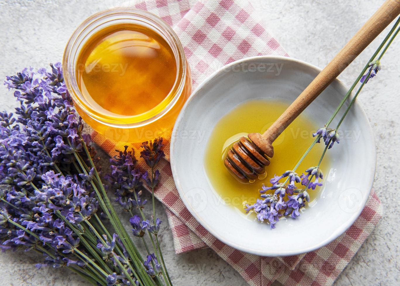 jarra com mel e flores frescas de lavanda foto