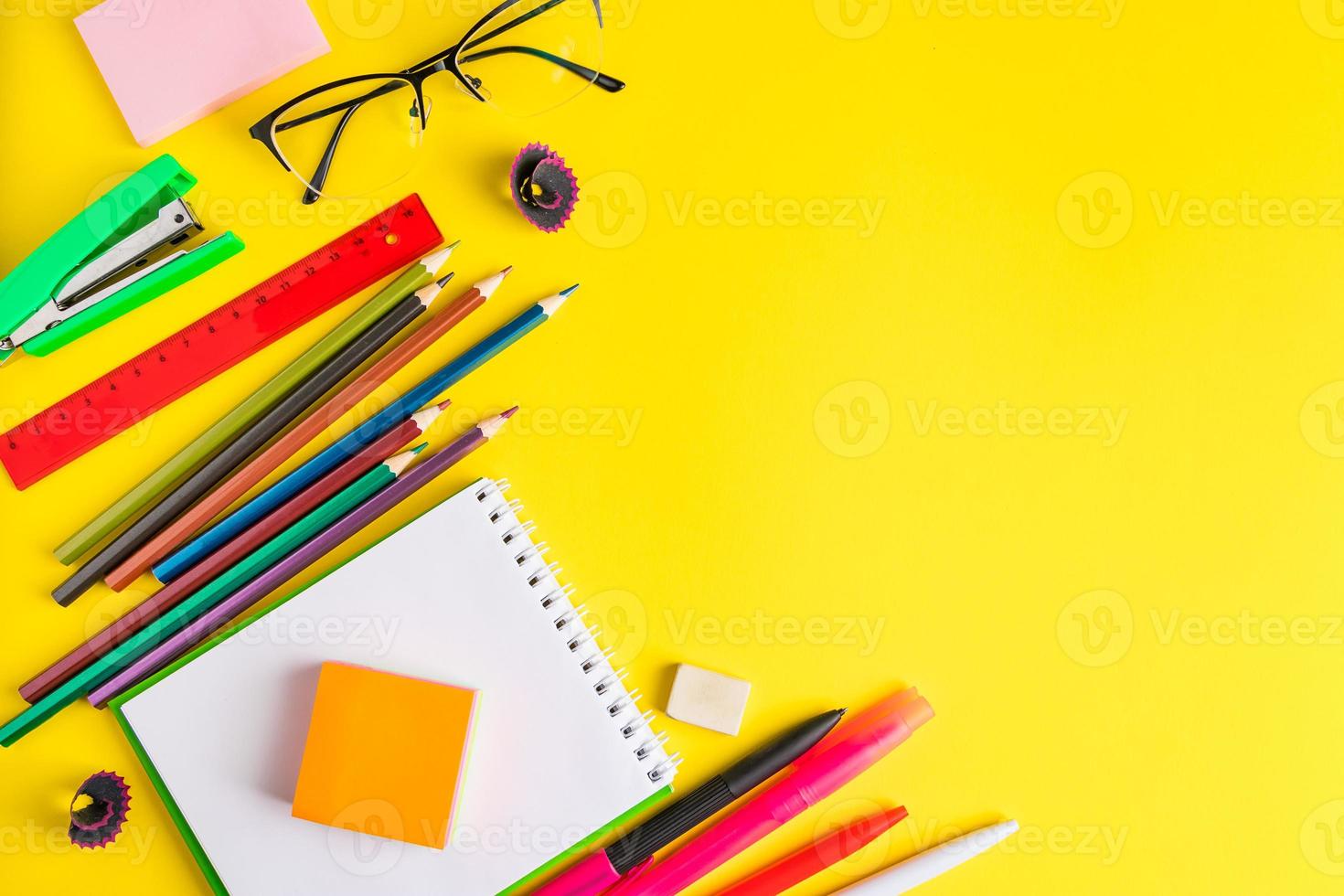 postura plana de artigos de papelaria em fundo amarelo. de volta à escola foto