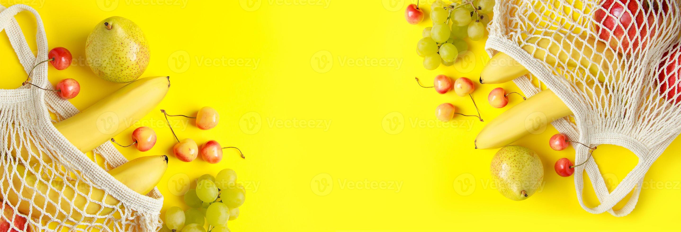 frutas maduras em saco de malha em fundo amarelo. foto