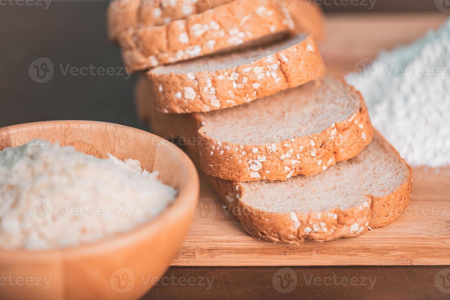 fatia pão de arroz e farinha em uma tábua de madeira foto