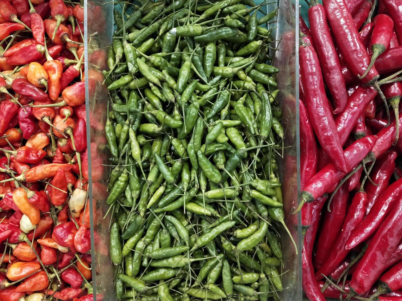 três pilhas de três tipos diferentes de chili fresco foto