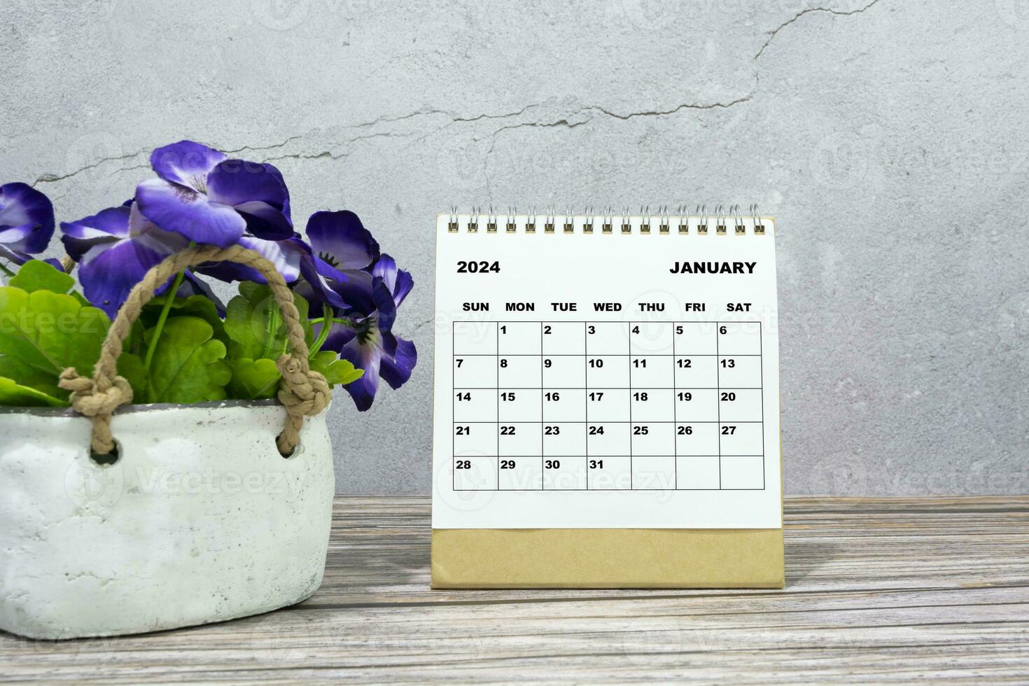 branco calendário em escritório de madeira escrivaninha com em vaso plantar. 2024 Novo ano conceito foto