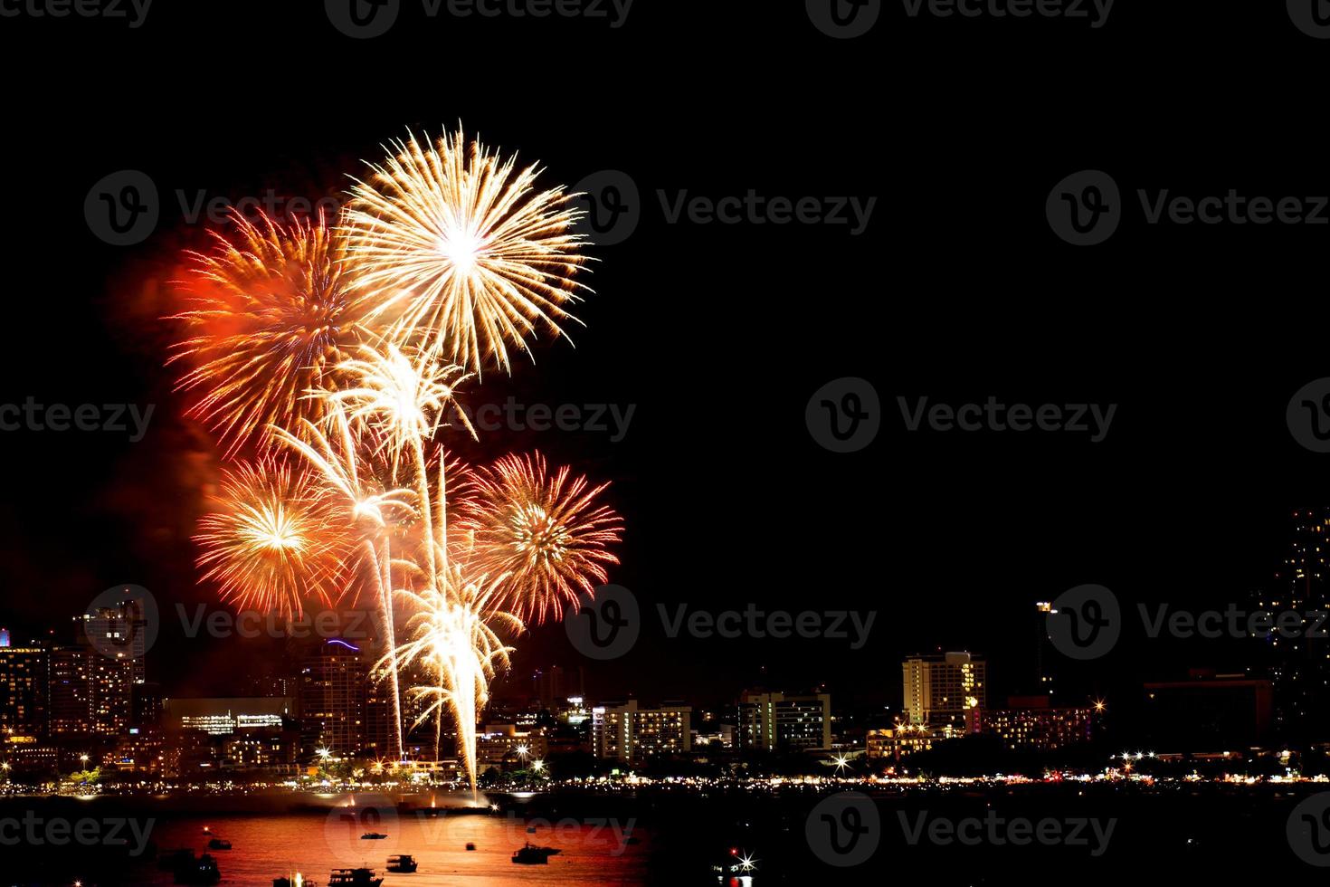 muitos fogos de artifício piscando com fundo de paisagem urbana de noite ano novo. foto