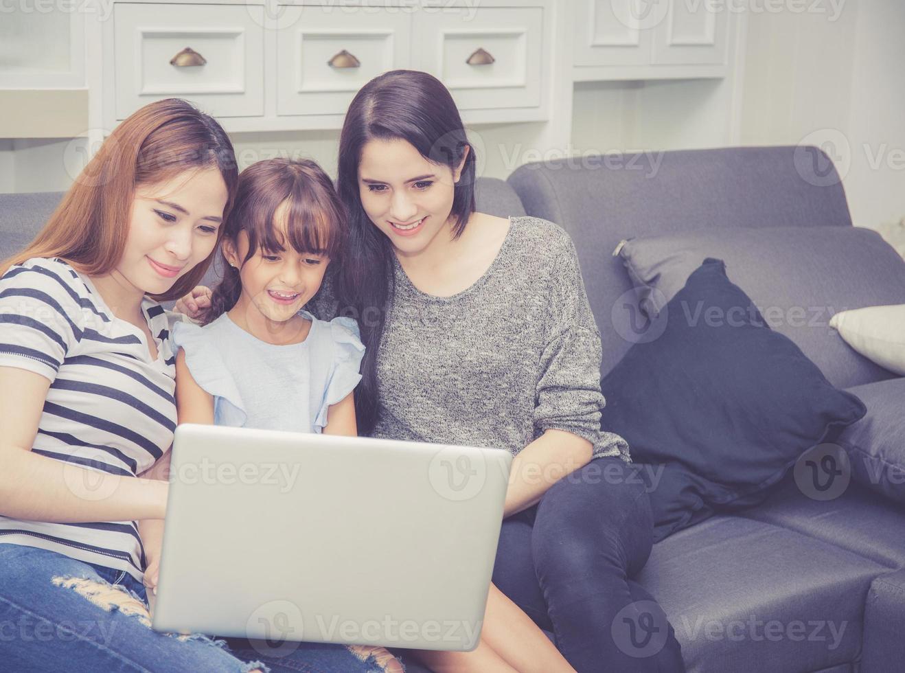 família e filha, tendo tempo juntos aprendendo com o uso do laptop. foto