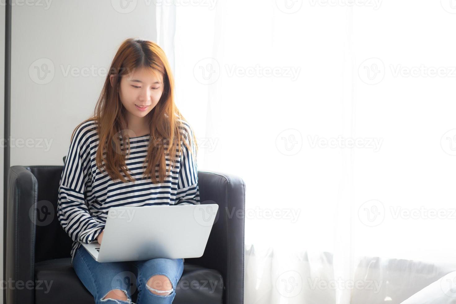 jovem mulher asiática usando laptop para lazer. foto