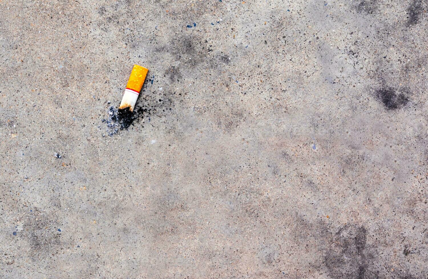 a ponta do cigarro caiu no chão de concreto foto