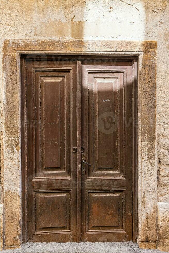 imagem do uma Castanho Entrada porta para uma residencial construção com a Antiguidade fachada foto