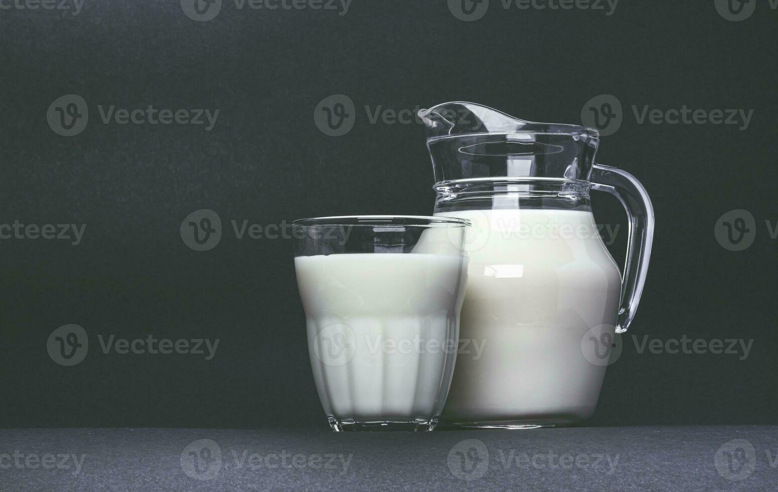 jarra e vidro copo do leite em Preto fundo foto