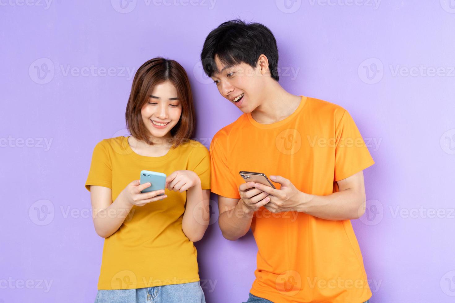 retrato de casal asiático, isolado em fundo roxo foto