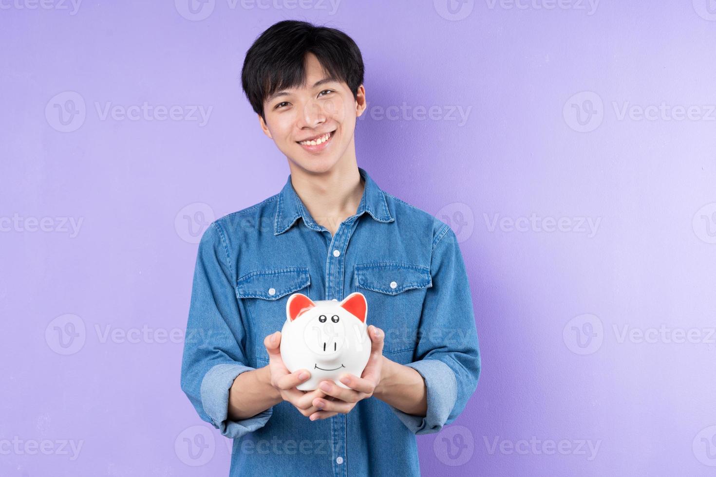 retrato de homem asiático de camisa azul, posando em fundo roxo foto