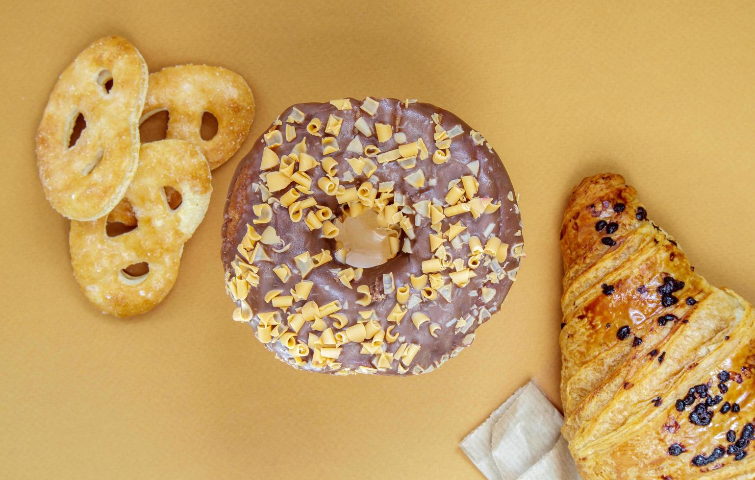 donut de chocolate fresco, croissant e biscoito isolado em delicado foto