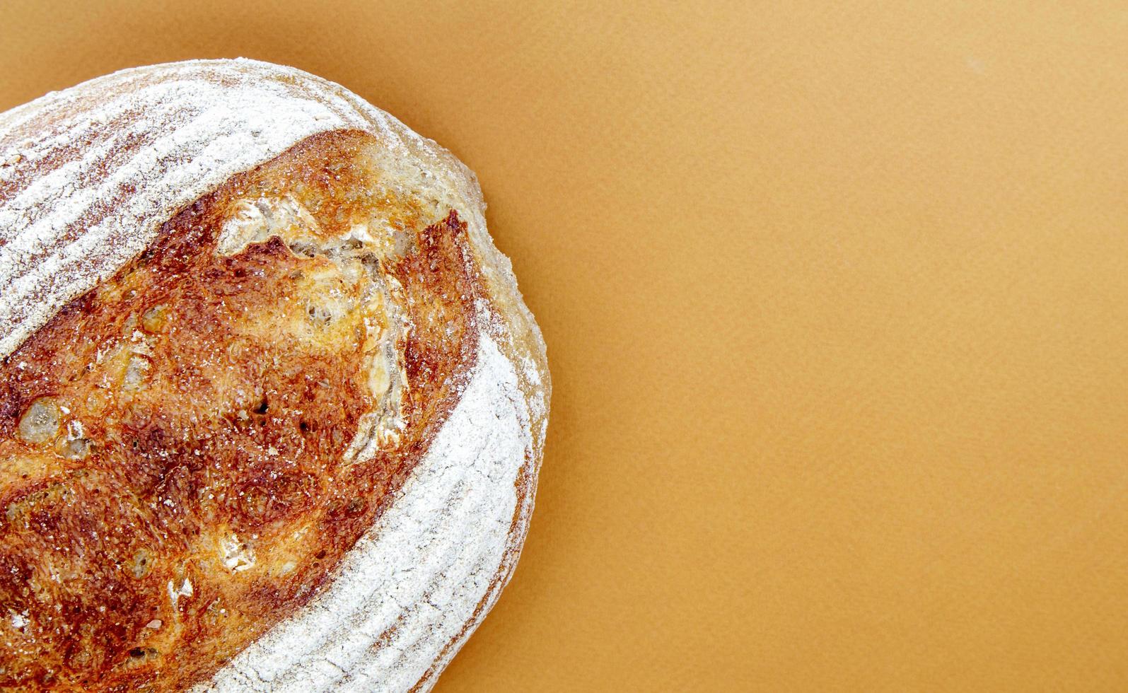 pão recém-assado com massa fermentada orgânica isolado em marrom ou café foto