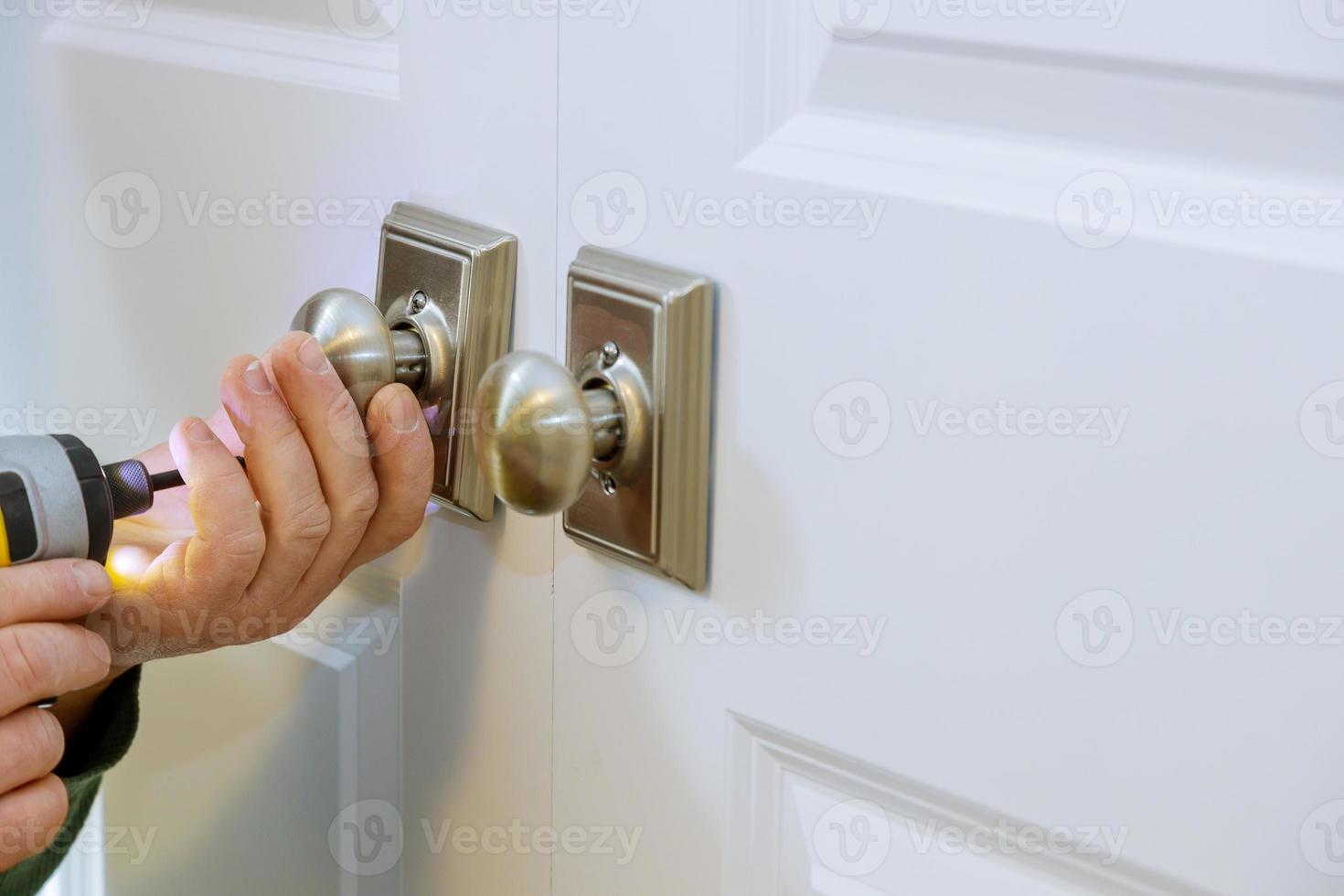 homem instalando a fechadura falsa da porta foto