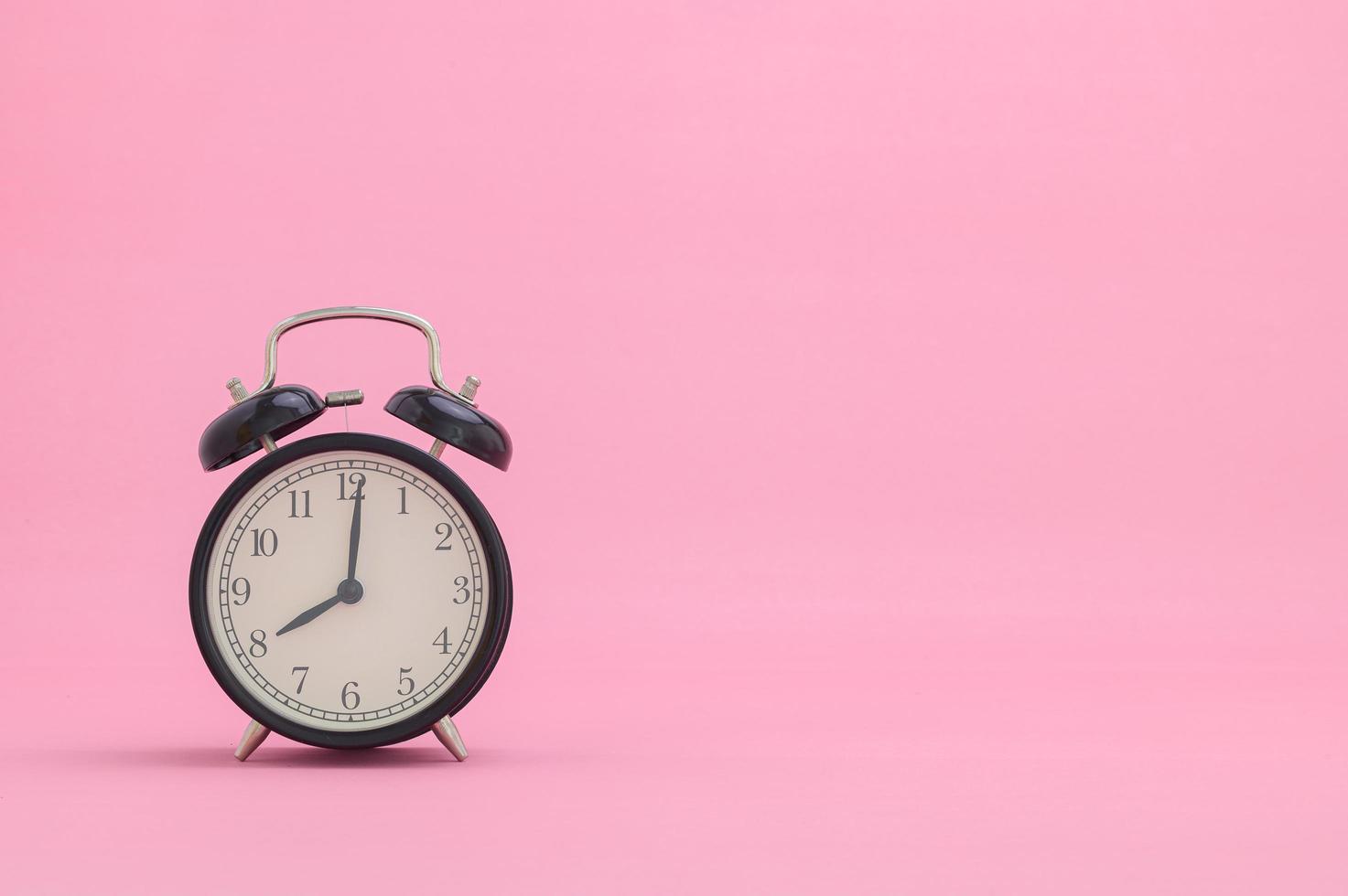 relógio mostrando as horas em um fundo rosa foto
