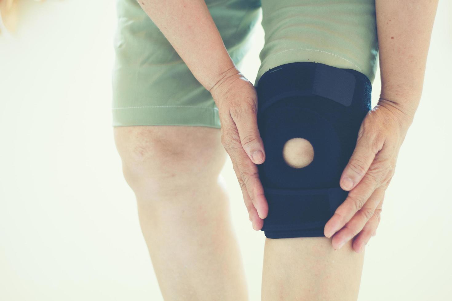 foco suave de mulheres asiáticas idosas com lesão no joelho foto