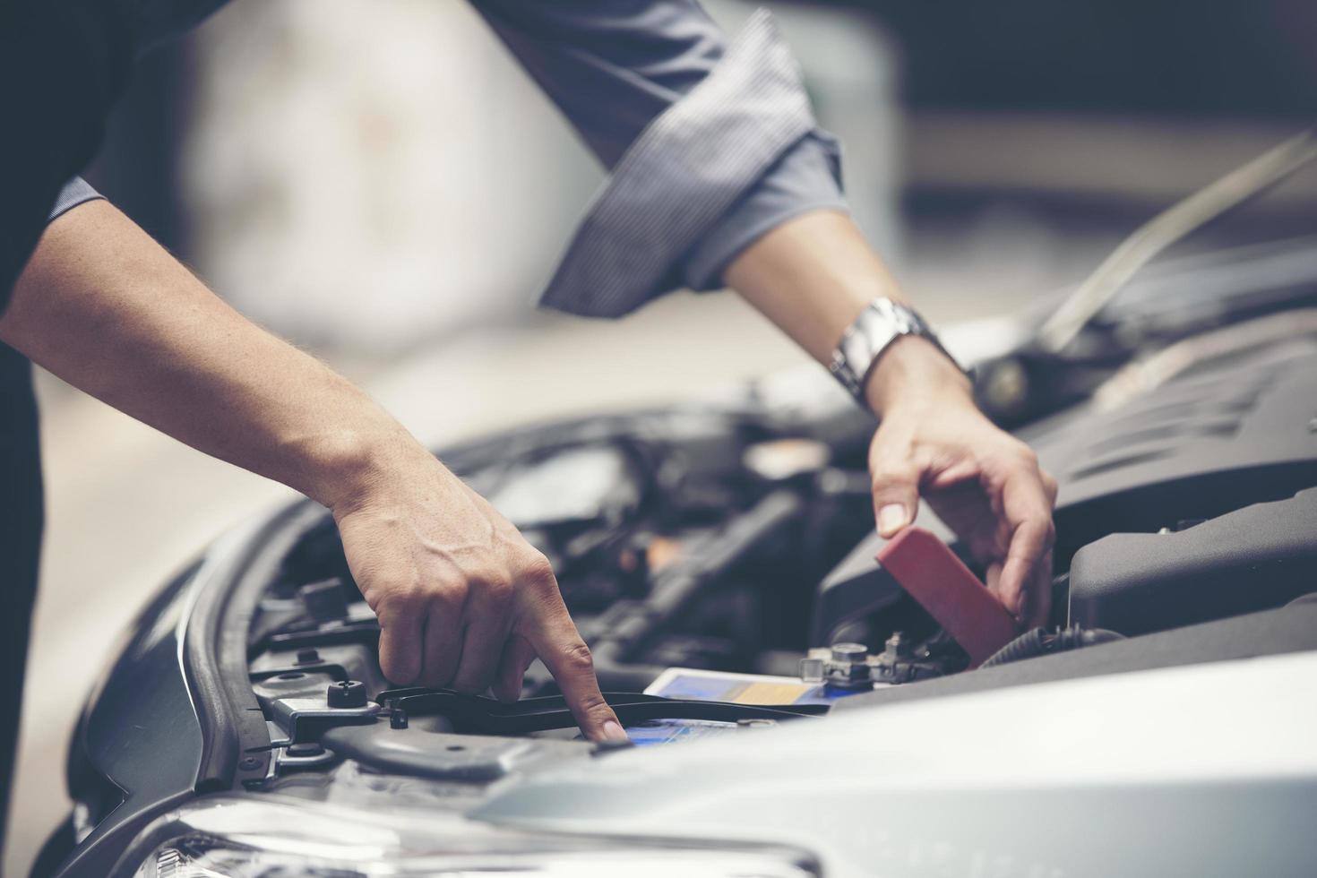 homem verificando o motor de um carro foto