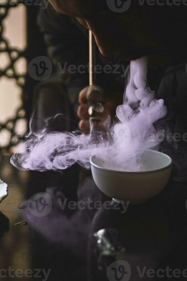 uma cara fuma narguilé dentro shisha Barra foto